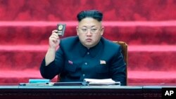 FILE: North Korean leader Kim Jong-un holds up a parliament membership certificate at a Supreme People's Assembly in Pyongyang, North Korea, on April 9, 2014. American Matthew Todd Miller has been detained in the country since April 10. 