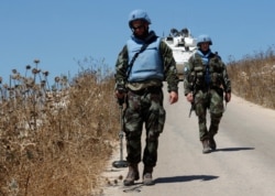 Irish U.N. peacekeepers use mine detectors as they patrol near the fields struck by Israeli army shells in the southern Lebanese-Israeli border village of Maroun el-Ras, Lebanon, Sept. 2, 2019.