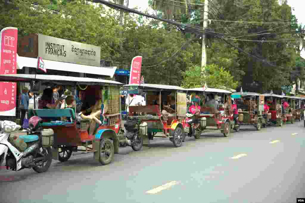 រ៉ឺម៉ក​កង់​បី​កំពុង​រង់​ចាំ​ដឹក​ភ្ញៀវជាតិ​និង​អន្តរជាតិ​ទៅ​ទស្សនា​​ស្នាដៃ​ថត​រូប​​​ដែល​ត្រូវ​បាន​ដាក់​បង្ហាញ​នៅ​តាម​ទីតាំង​ខុស​ៗ​គ្នា​ក្នុង​រាជធានី​ភ្នំពេញ​កាល​ពី​ថ្ងៃទី​០៦ ខែ​តុលា ឆ្នាំ ២០១៨។(ទុំ ម្លិះ/VOA)
