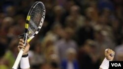 Petenis Spanyol Rafael Nadal mengangkat kedua tangannya setelah mengalahkan petenis Kroasia Marin Cilic di babak keempat Australia Terbuka hari Senin (24/1).