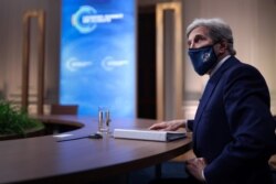 John Kerry, Special Presidential Envoy for Climate, looks up at a video screen while participating in a virtual Climate Summit with world leaders in the East Room at the White House in Washington, April 22, 2021.