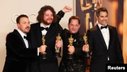 Команда фильма «Поток» – Гинтс Зилбалодис, Матисс Кажа, Рон Дайенс и Грегори Зальцман – позируют с «Оскаром» на церемонии вручения кинопремии в Лос-Анджелесе, 2 марта 2025 г.