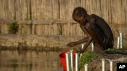 Seorang anak mengambil air dengan ember di daerah Old Fangak, negara bagian Jonglei, Sudan Selatan, Rabu, 25 November 2020. (Foto: AP)