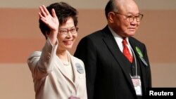 Carrie Lam waves after she won the election for Hong Kong's next Chief Executive as Woo Kwok-hing stands next to her in Hong Kong, March 26, 2017. 