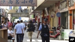 FILE - A policeman talks on his mobile as he patrols near the site of Sunday's attack in Kashgar in China's far western Xinjiang Uygur Autonomous Region, Aug. 2, 2011.