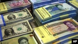 Iranian and U.S. banknotes are on display at a currency exchange shop in downtown Tehran, Iran, April 4, 2015.