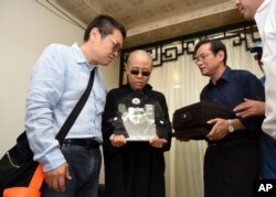 FILE - Liu Xia, wife of jailed Nobel Peace Prize winner and Chinese dissident Liu Xiaobo, holds a portrait of him during his funeral in Shenyang in northeastern China's Liaoning Province, July 15, 2017. Liu has now joined the ranks of those forcibly disappeared.