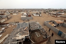 People walk in a shantytown near the port of Hodeida, Yemen, June 16, 2018.