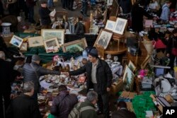 FILE - People buy items at a stall street in Barcelona, Spain, Monday, Dec. 18, 2017. Jittery businessmen in Catalonia have put their investment plans on ice as they brace for the region's parliamentary election, Dec. 21, 2017.