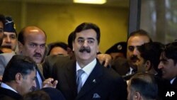 Yousuf Raza Gilani (au c.) arrive au tribunal le 13 fév. 2012 