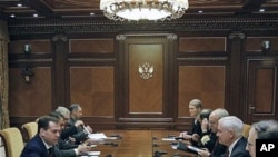 Russian President Dmitry Medvedev, left, speaks to US Defense Secretary Robert Gates, second right, during their meeting at which they discussed the planned missile defense system in Europe, at the Gorki residence outside Moscow, March 22, 2011