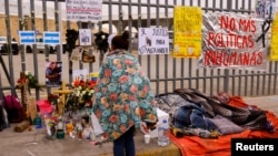 Migran tidur di samping altar di luar pusat penahanan migran di mana beberapa migran meninggal setelah terjadinya kebakaran di Ciudad Juarez, Meksiko, 30 Maret 2023. (REUTERS/Jose Luis Gonzalez)