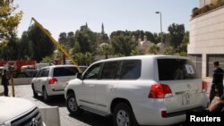 FILE - U.N. vehicles, transporting a team of experts from the Organization for the Prohibition of Chemical Weapons, leave their hotel in Damascus October 22, 2013.