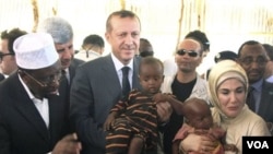 Presiden Somalia, Sharif Sheik Ahmed (kiri) mendampingi PM Turki Recep Tayyib Erdogan dan isterinya Emine Erdogan saat mengunjungi korban kelaparan di Mogadishu (19/8).