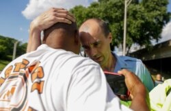 A Georgia State Patrol official hugs a protester, June 13, 2020, near the restaurant where Rayshard Brooks was shot and killed by police the night before, in Atlanta.