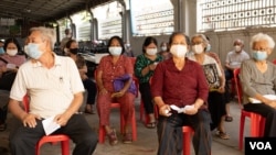 ប្រជាពលរដ្ឋដែលមានអាយុចាប់​ពី ៦០ឆ្នាំឡើង អង្គុយរង់ចាំចាក់វ៉ាក់សាំងបង្ការ​ជំងឺកូវីដ១៩ របស់ក្រុមហ៊ុន AstraZeneca នៅមន្ទីរពេទ្យបង្អែករាជធានីភ្នំពេញ កាលពីថ្ងៃទី២៣ ខែមីនា ឆ្នាំ២០២១។ (ទុំ ម្លិះ/វីអូអេ)