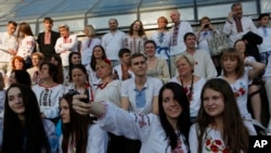 People wearing the traditional Ukrainian garment known as the vyshyvanka at a gathering in the center of Kyiv, Ukraine, on Thursday, May 21, 2015. (AP Photo/Sergei Chuzavkov)