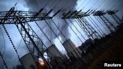 FILE - Water vapor rises from the cooling towers of the Jaenschwalde coal-fired power plant of Lausitz Energie Bergbau AG in Jaenschwalde, Germany, Jan. 24, 2019.