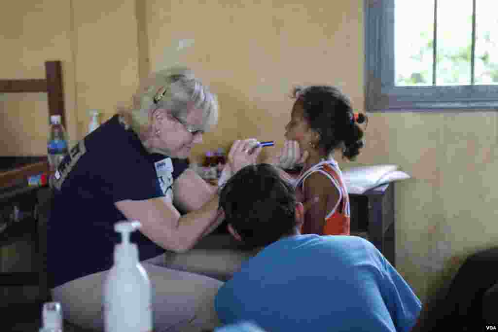 មន្ត្រីកងទ័ពអាកាសសហរដ្ឋអាមេរិកពិនិត្យធ្មេញរបស់កុមារីមួយរូប នៅស្រុកកំពង់ត្រាច ខេត្តកំពត កាលពីថ្ងៃពុធ ទី១៥ ខែមិថុនា ឆ្នាំ២០១៦។