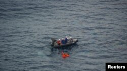 Crew memebrs of a boat which belongs to the Fisheries Agency conduct a rescue operation to North Korean crew members from a fishing vessel that sank after colliding with a Japanese patrol boat, in an area called the Yamato Shallows, in waters Japan says a