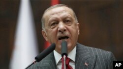 FILE - Turkey's President Recep Tayyip Erdogan addresses his MPs and supporters at parliament, in Ankara, Turkey, May 7, 2019.