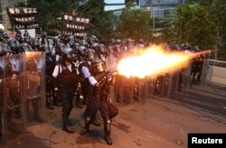 Police officers fire a tear gas during a demonstration against a proposed extradition bill in Hong Kong, China June 12, 2019.