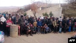 Syrians wait for the arrival of an aid convoy, Jan. 11, 2016, in the besieged town of Madaya as part of a landmark six-month deal reached in September for an end to hostilities in those areas in exchange for humanitarian assistance.