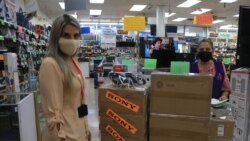 Carol Galvez, left, says sales at Liverpool electronics store have fallen by half amid the border closure. (Dylan Baddour/VOA)