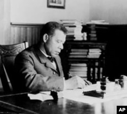 Tuskegee Institute President Booker T. Washington works at his desk in a photo taken around 1905.