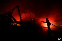 Fire crews work among destroyed homes at the Rancho Monserate Country Club community Thursday, Dec. 7, 2017, in Fallbrook, Calif.