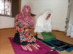 Rani Khan, a transgender woman who teaches the Koran at Pakistan's first transgender only madrasa or a religious school, prays with one of her students in Islamabad, Pakistan March 10, 2021. Picture taken March 10, 2021. REUTERS/Salahuddin NO RESALES. NO