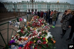 People look at flowers left for the plane crash victims at Dvortsovaya (Palace) Square in St. Petersburg, Russia, Nov. 2, 2015.