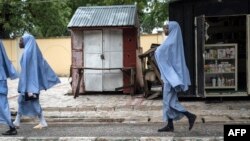 FILE - Girls walk home after school in Maiduguri on July 5, 2017.