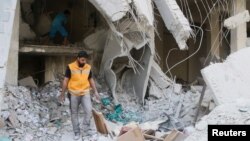A Red Crescent aid worker inspects scattered medical supplies after an airstrike on a medical depot in the rebel-held Tariq al-Bab neighborhood of Aleppo, Syria, April 30, 2016. 