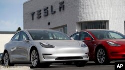 FILE - New 2018 Model 3 vehicles are seen on a Tesla dealer's lot in Littleton, Colorado, April 15, 2018.