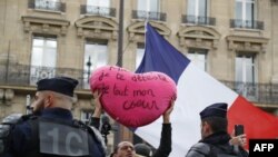 Un "gilet jaune" tient une pancarte en forme de cœur devant les Galeries Lafayette lors d'une manifestation anti-gouvernementale à Paris, le 28 septembre 2019. (AFP)