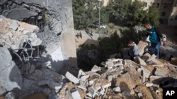 Palestinians inspect the damage of a destroyed house following a late night Israeli missile strike in town of Beit Lahiya, Northern Gaza Strip, May. 6, 2019.