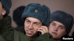 A conscript for the Russian army talks on a mobile phone at a recruiting station in Stavropol in southern Russia, October 20, 2010
