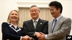U.S. Secretary of State Hillary Rodham Clinton, left, South Korean Foreign Minister Kim Sung-hwan, center, and Japanese Foreign Minister Koichiro Gemba shake hands before their trilateral meeting during the ASEAN Regional forum in Phnom Penh, Cambodia, Ju