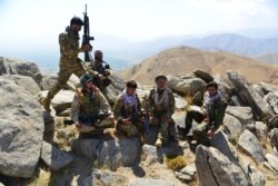 Members of anti-Taliban Afghan resistance forces rest as they patrol on a hilltop in the Darband area of Anaba district, Panjshir province, Afghanistan, Sept. 1, 2021.