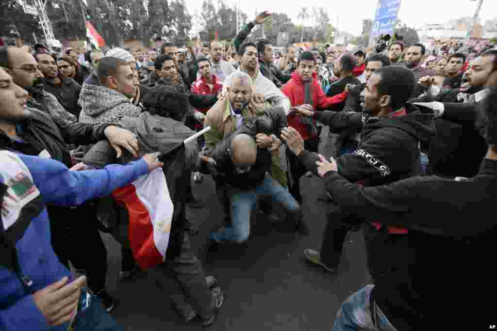 Egyptian President Mohammed Morsi&rsquo;s supporters beat an opponent, center, during clashes outside the presidential palace, in Cairo, Egypt, Dec. 5, 2012.