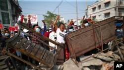 Protesters shout slogans as police arrive during a protest against the military coup in Mandalay, Myanmar, Feb. 28, 2021.
