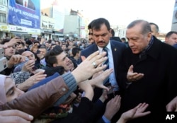 Turkey's President Recep Tayyip Erdogan (right) speaks with his supporters as he arrives for the openıng ceremony at a hıgh school in Istanbul, Dec. 3, 2016.