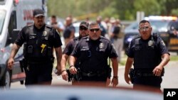 FILE - Police walk near Robb Elementary School following shootings on May 24, 2022, in Uvalde, Texas. A federal report released on Jan. 18, 2024, into the halting law enforcement response to the shootings revived scrutiny of the hundreds of officers who responded to the massacre.