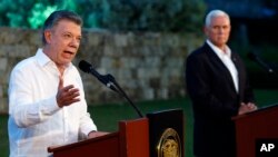 Presiden Kolombia Juan Manuel Santos (kiri), berbicara kepada media, sementara Wakil Presiden Mike Pence ikut mendengarkan dalam sebuah konferensi pers bersama di Cartagena, Kolombia, 13 Agustus, 2017.