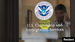 FILE - A security guard looks out of the U.S. Citizenship and Immigration Services offices in New York, Aug. 15, 2012.