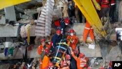 터키 서부 이즈미르시의 붕괴된 건물 잔해 더미에서 구조요원들이 31일, 시신을 운반하고 있다.