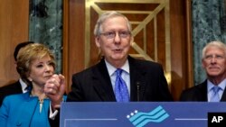 Senate Majority Leader Mitch McConnell, R-Ky., flanked by, Small Business Administration Administrator Linda McMahon, left, and Sen. Roger Wicker, R-Miss., speaks to a group of small business owners as Republicans work to pass their sweeping tax bill, a blend of generous tax cuts for businesses and more modest tax cuts for families and individuals, on Capitol Hill in Washington, Thursday, Nov. 30, 2017.