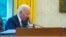 In this image made through a window, President Joe Biden talks on the phone with Ukrainian President Volodymyr Zelenskiy from the Oval Office of the White House in Washington, Dec. 9, 2021.