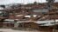 FILE - A man watches a stream from his home in Nairobi's Kibera slum, Kenya, Dec. 3, 2019. 